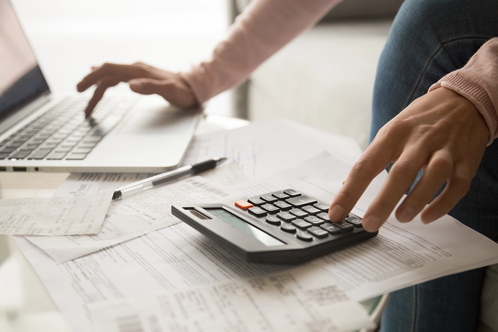 Someone using an online loan calculator on their laptop